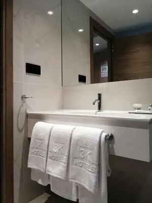 a bathroom with a sink and towels on a tub at Hotel 3K Faro Aeroporto in Faro