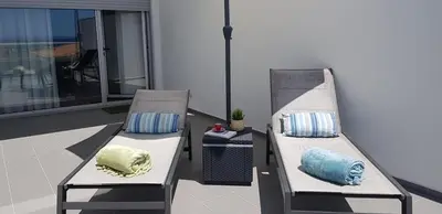 two chairs with pillows sitting on a balcony at 