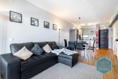 a living room with a black couch and a kitchen at Forte 303 - Dream Lodging in Albufeira