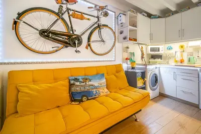 a bike hanging on a wall above a couch in a kitchen at Casinha da Ti Babel in Faro
