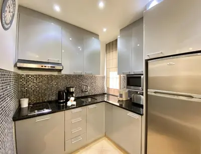 a kitchen with white cabinets and a stainless steel refrigerator at Tália X - Near the beach - Vilamoura in Vilamoura