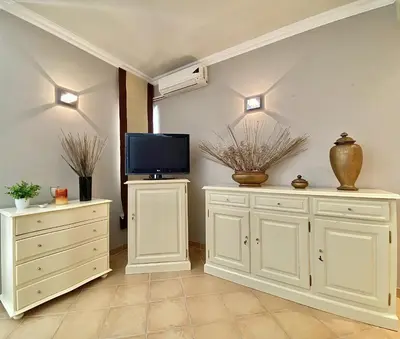 a living room with white cabinets and a flat screen tv at Tália X - Near the beach - Vilamoura in Vilamoura