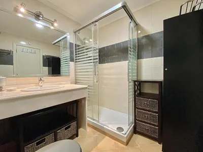a bathroom with a sink and a glass shower at Tália X - Near the beach - Vilamoura in Vilamoura