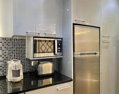 a kitchen with a stainless steel refrigerator and a microwave at Tália X - Near the beach - Vilamoura in Vilamoura