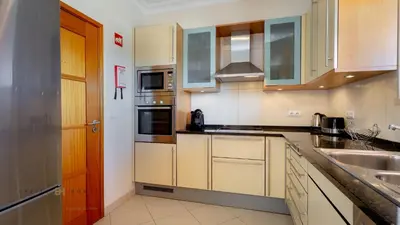 a kitchen with white cabinets and a sink at Greice Homes-Luxury 2 bed en-suite south facing & Golf view in Quarteira