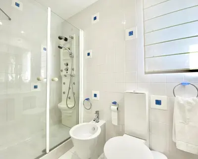 a white bathroom with a toilet and a shower at Sunset Marina - Sea view - Vilamoura in Vilamoura