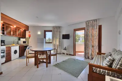 a kitchen and living room with a table and a dining room at Bellavista Avenida By BeGuest in Albufeira