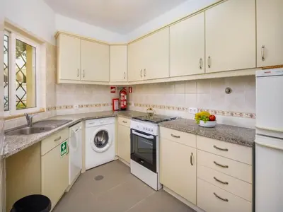 a kitchen with white cabinets and a washer and dryer at Villa Oceano Golf 482 2 Bedrooms Sea Views A Stone's Throw To The Beach in Vale do Lobo