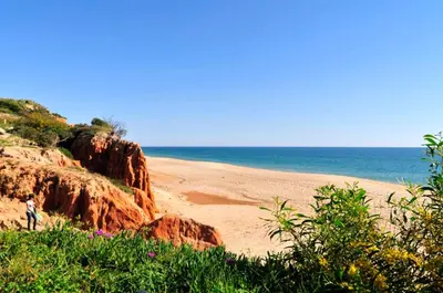 a person standing on a beach near the ocean at Charming Vale Do Lobo Villa Casa Vale Do Lobo 832A 3 Bedrooms in Vale do Lobo