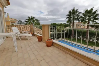 a balcony with a table and chairs and palm trees at Villa Varandas Do Lago 5 Bedroom Villa Private Pool Table Tennis in Vale do Lobo