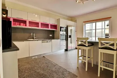 a large kitchen with white cabinets and a table and chairs at Villa Varandas Do Lago 5 Bedroom Villa Private Pool Table Tennis in Vale do Lobo