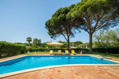 a swimming pool with chairs and an umbrella at Villa Vale Do Lobo 626 3 Bedrooms Private Pool Short Walk To The Praca in Vale do Lobo