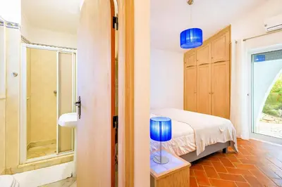 a bedroom with a bed and a bathroom with a window at Charming Vale Do Lobo Villa Private Pool Villa Vale Do Garro 51 in Vale do Lobo