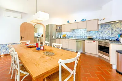 a large kitchen with a wooden table and chairs at Charming Vale Do Lobo Villa Private Pool Villa Vale Do Garro 51 in Vale do Lobo