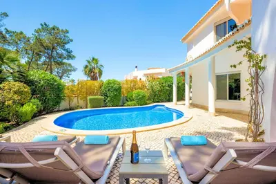 a villa with a swimming pool and two chairs at Charming Vale Do Lobo Villa Private Pool Villa Vale Do Garro 51 in Vale do Lobo