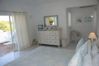 a bedroom with a bed and a dresser and a mirror at Vale Do Lobo Villa 4 Bedrooms Villa Vale Do Lobo 186 Swimming Pool in Vale do Lobo