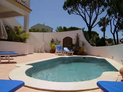 a small swimming pool in a patio with two chairs at Vale Do Lobo Villa 4 Bedrooms Villa Vale Do Lobo 186 Swimming Pool in Vale do Lobo