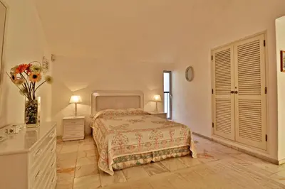 a bedroom with a bed and a vase of flowers at Villa Quadradinhos 3Q 4 Bedrooms Private Pool Short Walk To The Praca in Vale do Lobo