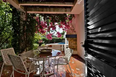 a patio with a table and chairs and flowers at Villa Quadradinhos 3Q 4 Bedrooms Private Pool Short Walk To The Praca in Vale do Lobo