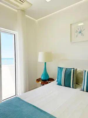 a bedroom with a bed with a blue lamp at Seafront Apartment in Quarteira in Quarteira
