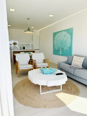 a living room with a couch and a table at Seafront Apartment in Quarteira in Quarteira