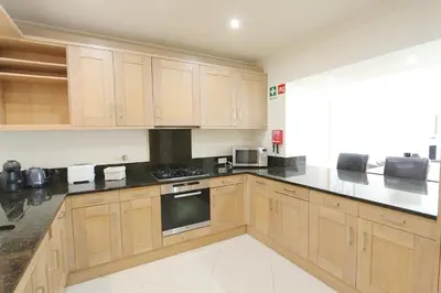 a kitchen with wooden cabinets and black counter tops at Villa Casa da Luz, Palmyra 173 - Clever Details in Vilamoura