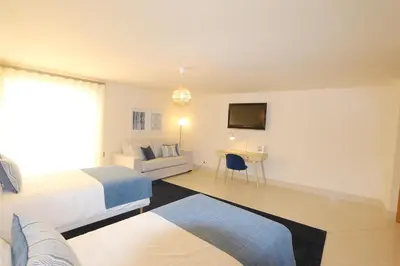 a hotel room with two beds and a television at Villa Casa da Luz, Palmyra 173 - Clever Details in Vilamoura