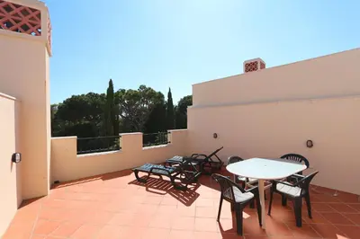 a patio with tables and chairs on a balcony at Villa Casa da Luz, Palmyra 173 - Clever Details in Vilamoura