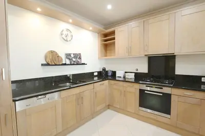 a kitchen with wooden cabinets and black counter tops at Villa Casa da Luz, Palmyra 173 - Clever Details in Vilamoura
