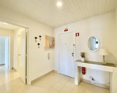 a hallway with a white door and a mirror at Tália XI - Near the beach - Vilamoura in Vilamoura
