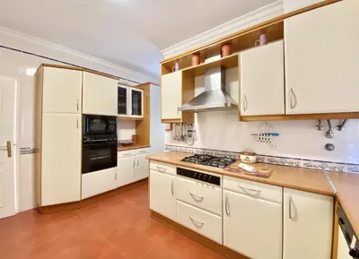 a kitchen with white cabinets and a stove top oven at Vila Pereira - Private Pool - Vilamoura in Vilamoura