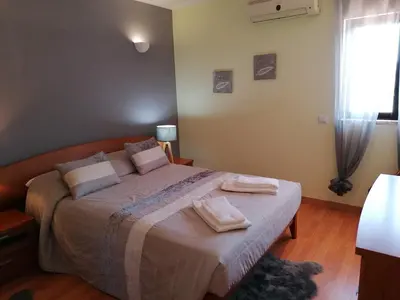 a bedroom with a large bed with two towels on it at Bel Appartement 2 chambres au cœur d’Albufeira, proche de la magnifique plage de Oura et des loisirs in Albufeira