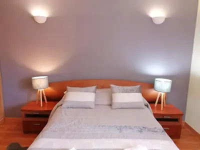 a bedroom with a large bed with two lamps at Bel Appartement 2 chambres au cœur d’Albufeira, proche de la magnifique plage de Oura et des loisirs in Albufeira
