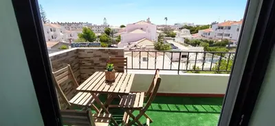 a table and chairs on a balcony with a view at Bel Appartement 2 chambres au cœur d’Albufeira, proche de la magnifique plage de Oura et des loisirs in Albufeira