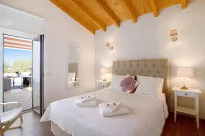 a bedroom with a white bed with a dresser and a tv at Villa Rodrigues Apartment I in Boliqueime