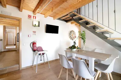 a living room with a table and chairs and a staircase at Villa Rodrigues Apartment I in Boliqueime