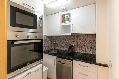 a kitchen with white cabinets and a microwave at Villa Rodrigues in Boliqueime