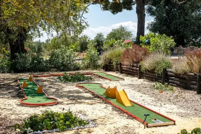 a garden with a play set in the sand at Villa Rodrigues in Boliqueime