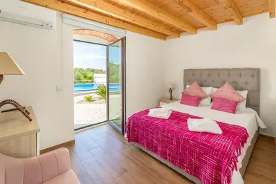 a bedroom with a large bed with a red blanket at Villa Rodrigues in Boliqueime