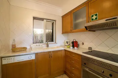 a kitchen with wooden cabinets and a stove top oven at Albufeira Apartment in Albufeira