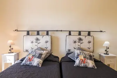 a bedroom with two beds and a door to a patio at Albufeira Apartment in Albufeira