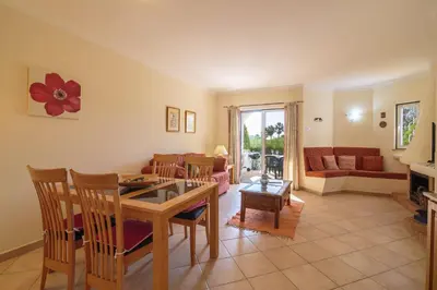 a living room with a table and chairs and a couch at Albufeira Apartment in Albufeira
