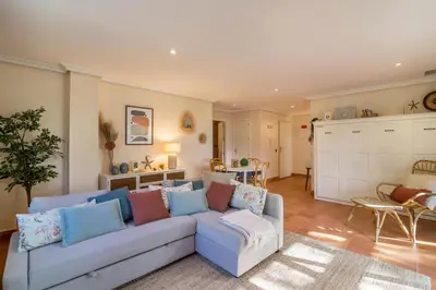 a living room with a blue couch and a kitchen at Falésia Pine Spot in Albufeira