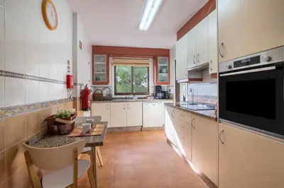 a kitchen and living room with a table and a dining room at Falésia Pine Spot in Albufeira