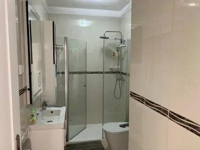 a bathroom with a shower and a toilet and a sink at Apartamento Frente praia in Quarteira