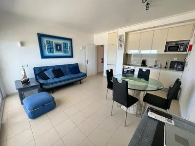 a living room with a blue couch and a table at Apartamento Frente praia in Quarteira