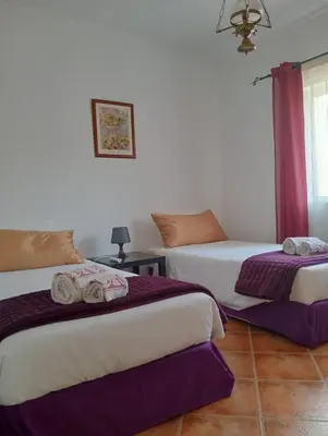 a hotel room with two beds and a couch at Villa Núria in Loulé