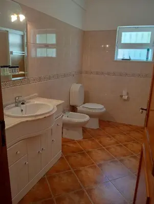 a bathroom with a sink and a toilet and a mirror at Villa Núria in Loulé