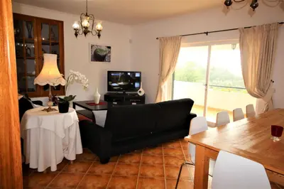 a living room with a black couch and a table at Villa Núria in Loulé