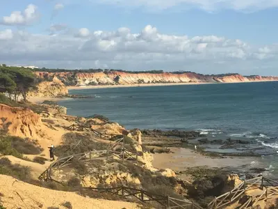 a person standing on a beach near the ocean at Pinetops holidays Apartment in Albufeira